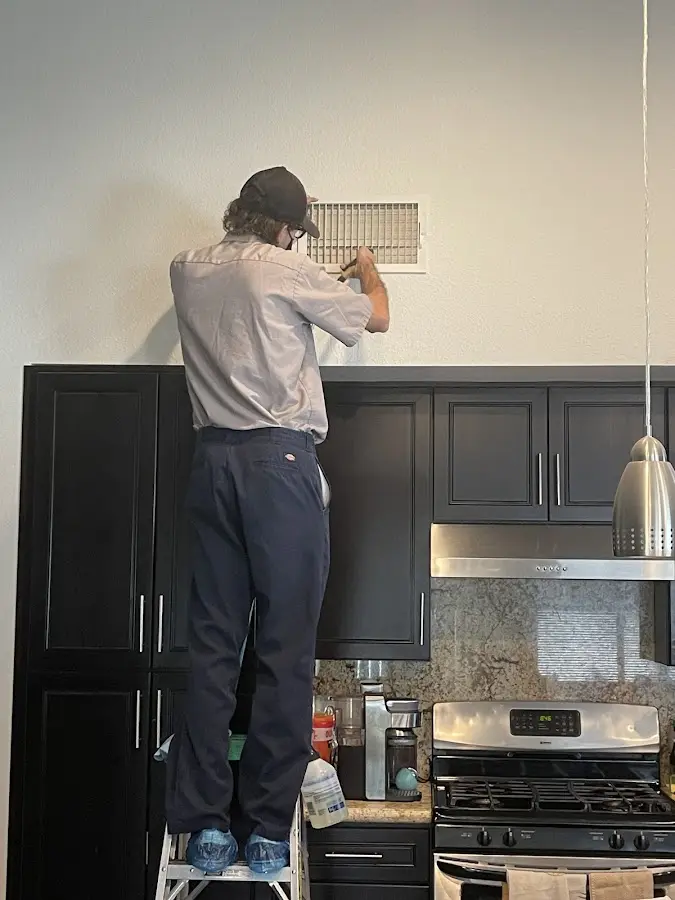 Technician inspecting an air vent during HVAC service in Lower Windsor